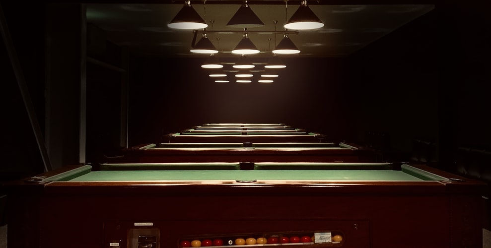 Pool tables lined up in a recreational center