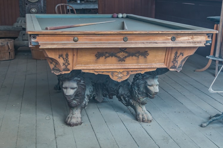 Ceramic lion sculpture adding considerable weight to a pool table