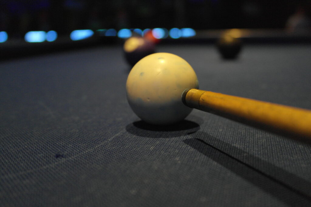 Pool cue aiming at a ball