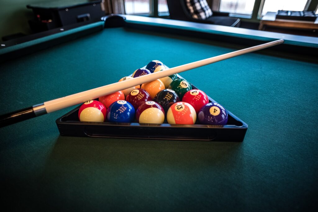 A cue stick placed on top of billiard balls