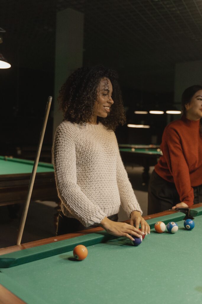 Woman and friends playing a game of pool