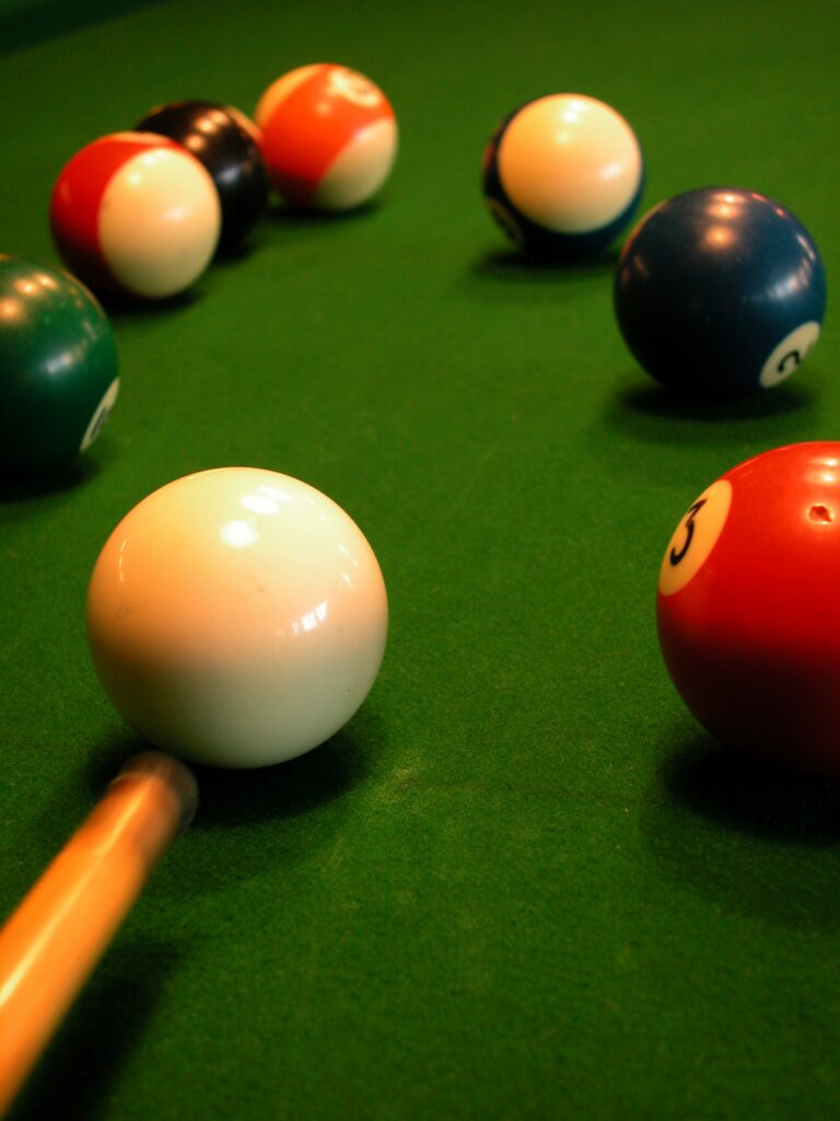 Pool cue aiming at a ball