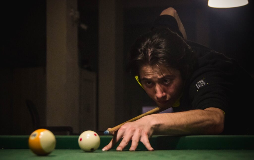 Man focused on hitting cue ball