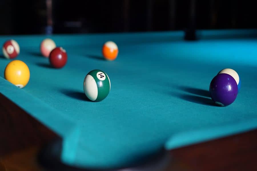 Pool table with cue balls scattered on top