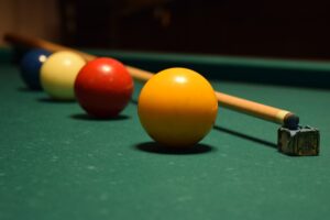 A pool stick with four pool balls on a billiard table